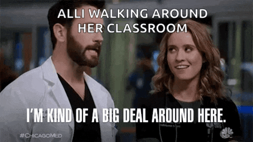 a man and a woman standing next to each other in a classroom .