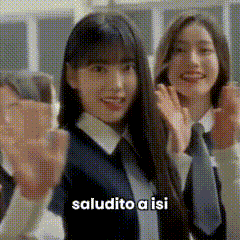 a group of girls in school uniforms are waving their hands and the words saludito a isi are on the bottom .