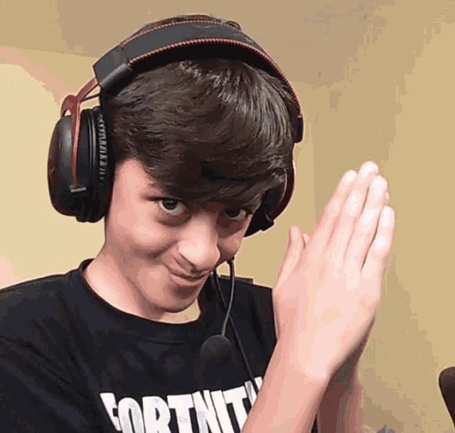 a young boy wearing headphones and a shirt that says fortnit