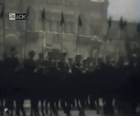 a blurred image of soldiers marching with a 24 aok sign in the corner