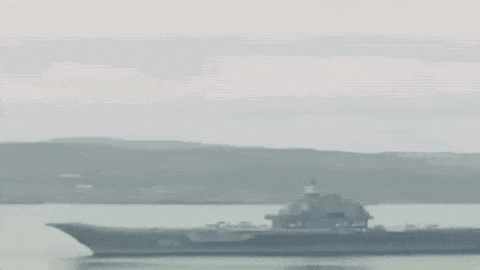 a large ship is floating on top of a large body of water .