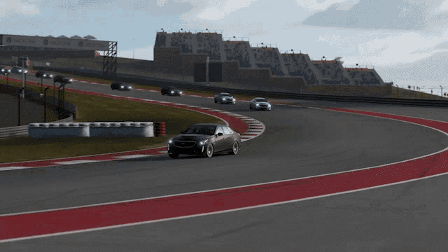 a black car is driving on a race track with a delta sign in the background