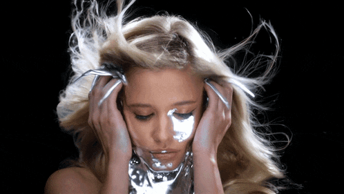 a woman with her hair blowing in the wind is wearing headphones