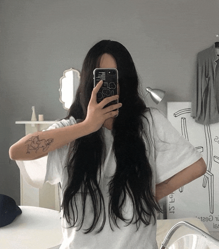 a woman taking a picture of herself in a mirror with a phone case that says ' i 'm sorry '