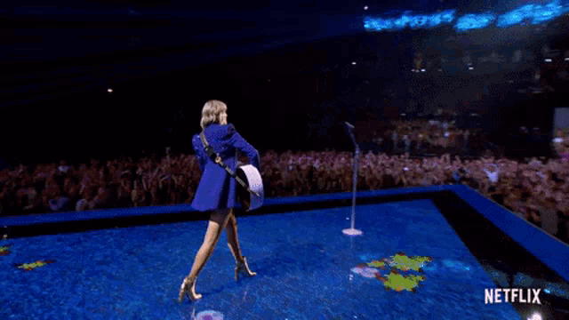 a woman is playing a guitar on a stage with netflix written on the bottom