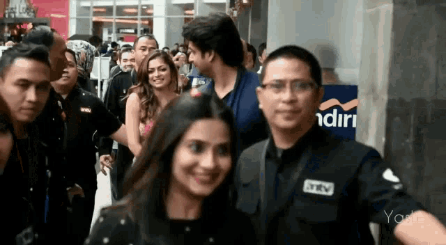 a group of people are walking in front of a building that says mandiri on it