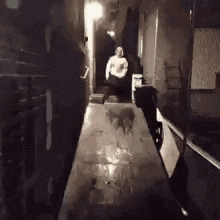 a person is walking down a hallway with a table in the foreground .