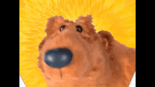a close up of a teddy bear with a yellow background .