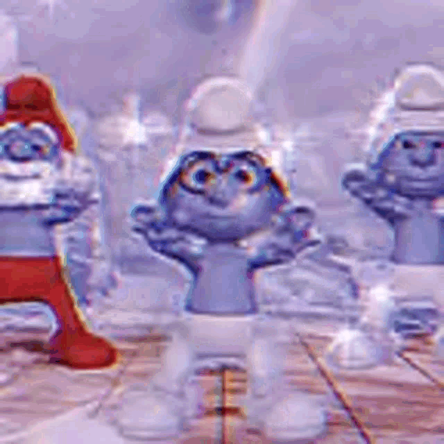 three smurfs are standing on a wooden floor .
