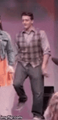 a man in a plaid shirt is dancing on stage .