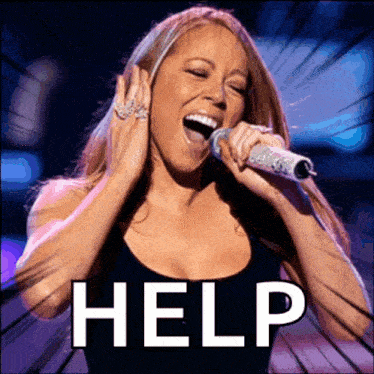 a woman singing into a microphone with the word help written on the bottom