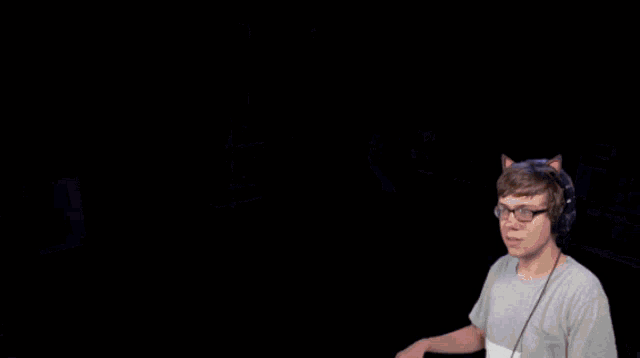 a man wearing headphones stands in front of a shelf that says e on it