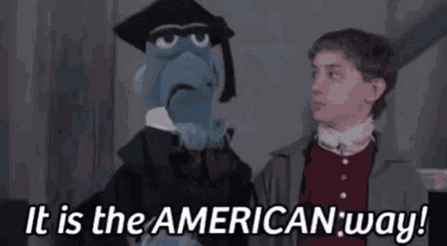 a puppet is standing next to a boy and saying `` it is the american way '' .