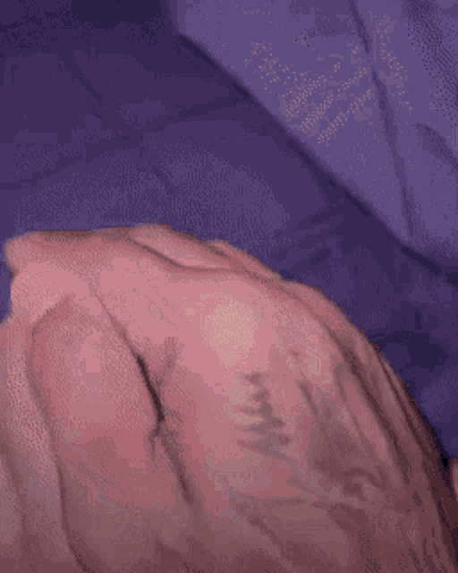 a close up of a person 's hand with a tattoo of a cross on it .