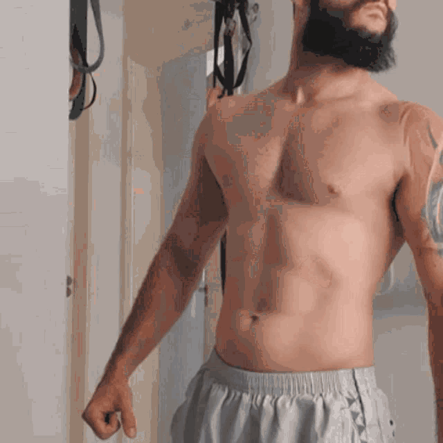a shirtless man with a tattoo on his shoulder
