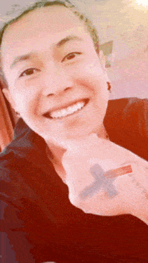 a woman with a cross tattoo on her arm smiles
