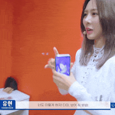 a woman is holding a cell phone in front of a sign that says twice