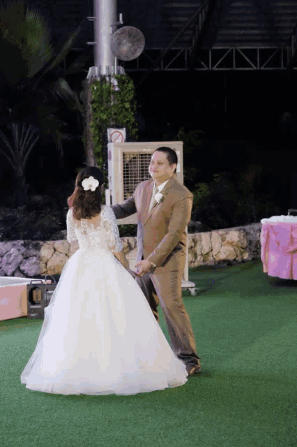 a bride and groom are dancing in front of an air conditioner