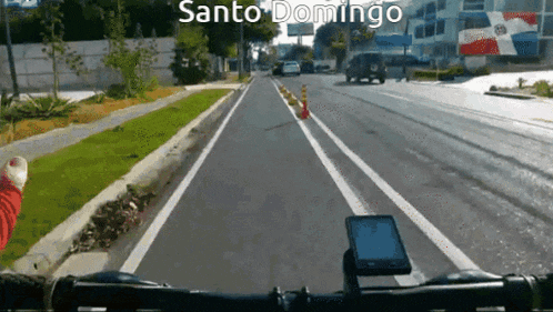 a person riding a bike down a street with santo domingo written on the bottom of the screen