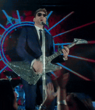 a man singing into a microphone while holding a guitar