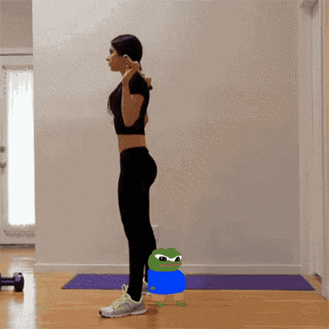 a woman is doing squats with a frog sitting on her back