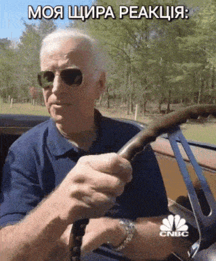 a man wearing sunglasses is driving a car with cnbc written on the bottom