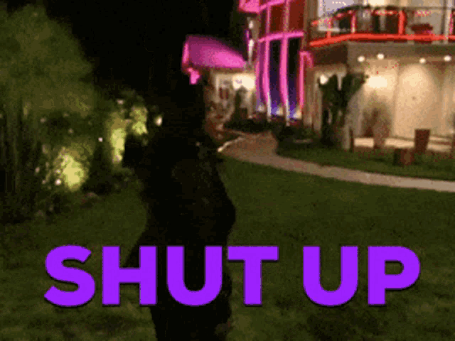 a woman stands in front of a house with the words shut up written in purple