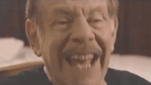 a close up of a man making a funny face while sitting at a table .