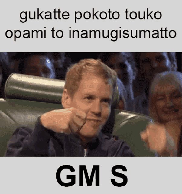 a man sitting in front of a crowd giving a thumbs up with gms written below him