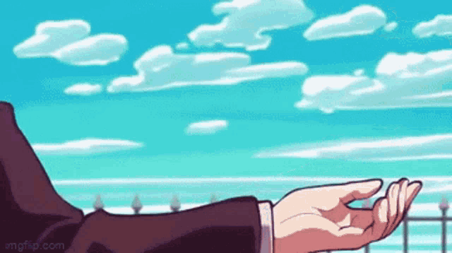 a person 's hand is reaching out towards a blue sky with clouds