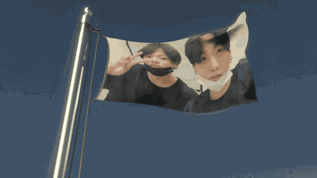 a flag with a picture of two young men wearing face masks
