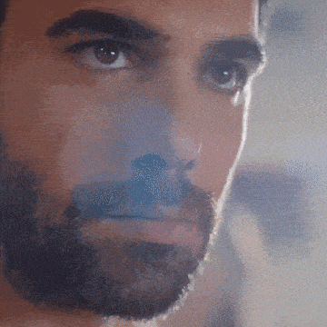 a close up of a man 's face with a beard and smoke coming out of his nose .