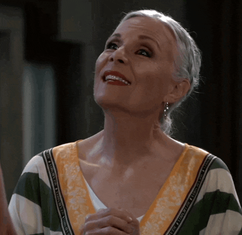 a woman wearing a green and white striped shirt with a yellow border that says ' abercrombie ' on it