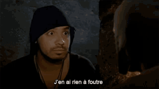 a man in a black hat is talking to another man in french