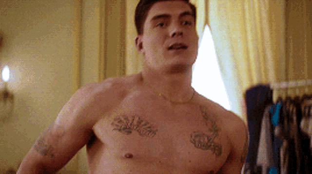 a shirtless man with tattoos on his chest