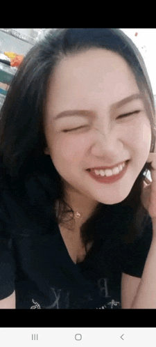 a woman is smiling with her eyes closed and her mouth open .
