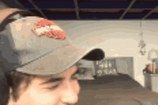 a man wearing a baseball cap with a red and white emblem on it