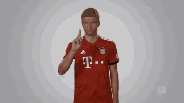 a man wearing a red t-mobile shirt points upwards