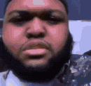 a close up of a man 's face with a beard .