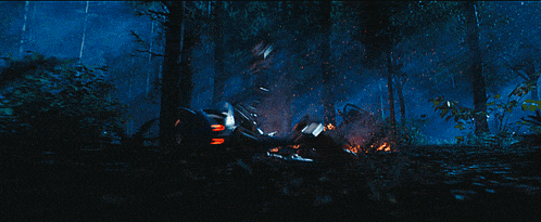 a helicopter is flying through a dark forest