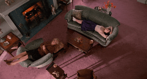 a woman laying on a green couch in a living room