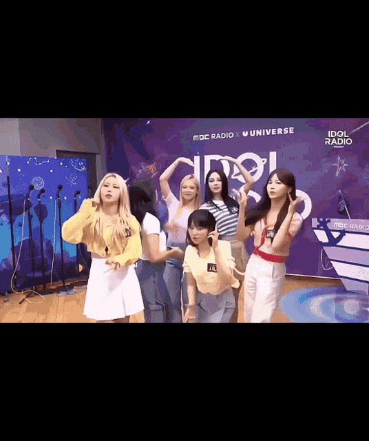 a group of girls are posing for a picture in front of a sign that says idol radio universe