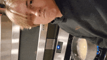 a man cooking in front of a stainless steel microwave that says ' stainless steel ' on the front