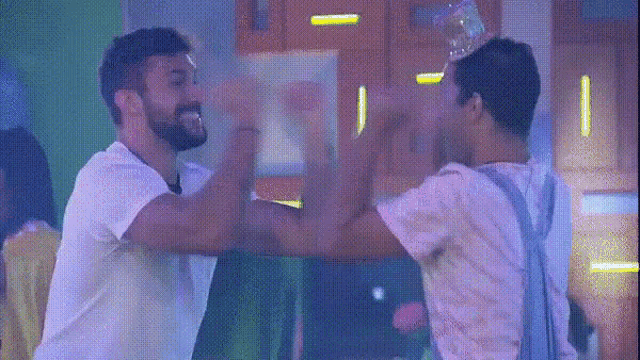 two men are giving each other a high five