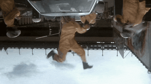 a man in a yellow jumpsuit is jumping from a car