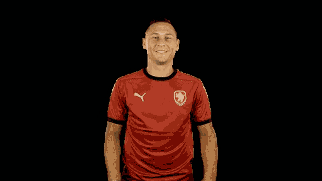 a man wearing a red shirt with a puma logo on the front