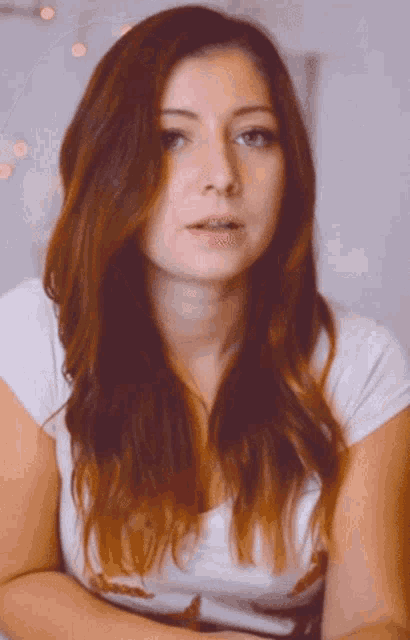 a woman with long red hair and braces on her teeth