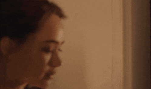 a close up of a woman 's face with her eyes closed in a room .