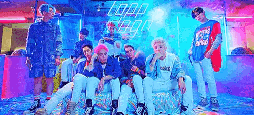 a group of young men are posing for a picture while sitting on a couch in a room .