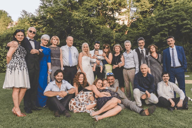 a large group of people are posing for a picture in a park